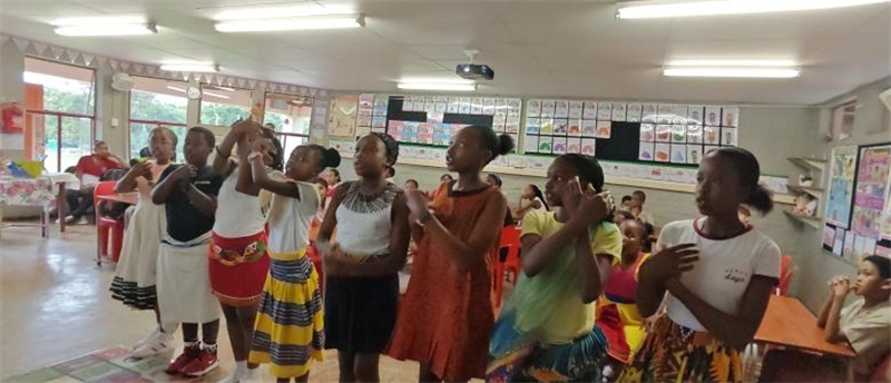 南非學(xué)生展示民族服飾，合唱《聽我說謝謝你》。