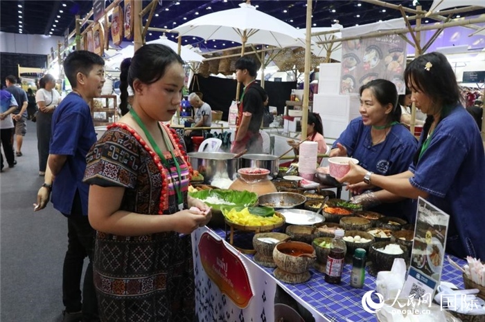 游客在攤位前購買特色美食。朱瀟逸攝