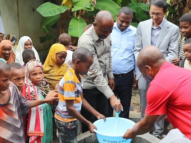 在日前舉行的安全供水工程揭牌儀式上，當(dāng)?shù)匦∨笥言诠┧c(diǎn)接水。 施亮攝