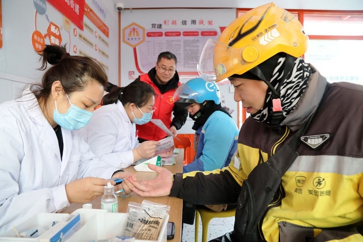 2025年3月5日，志愿者在山東省棗莊市市中區(qū)一工會驛站為外賣員免費(fèi)測量血糖。新華社發(fā)（王海楠攝）