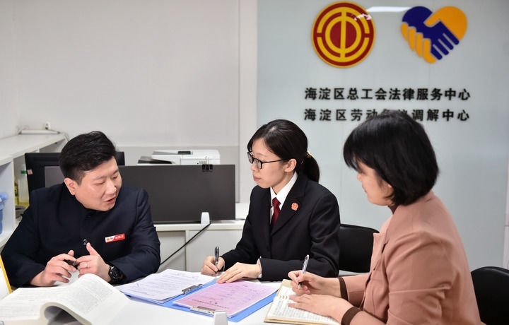 2025年3月6日，在北京市海淀區(qū)總工會勞動爭議調(diào)解中心，海淀區(qū)人民法院法官王琰（中）與該中心工作人員就糾紛化解情況進(jìn)行溝通。新華社記者 趙婷婷 攝