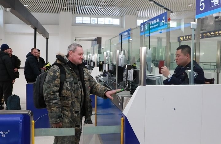 2024年12月10日，在黑河公路口岸旅檢大廳，黑河出入境邊防檢查站民警為首班次客車(chē)入境旅客辦理邊檢通關(guān)手續(xù)。當(dāng)日，中國(guó)黑河公路口岸—俄羅斯卡尼庫(kù)爾干公路口岸旅客運(yùn)輸正式開(kāi)通。新華社發(fā)（劉松攝）