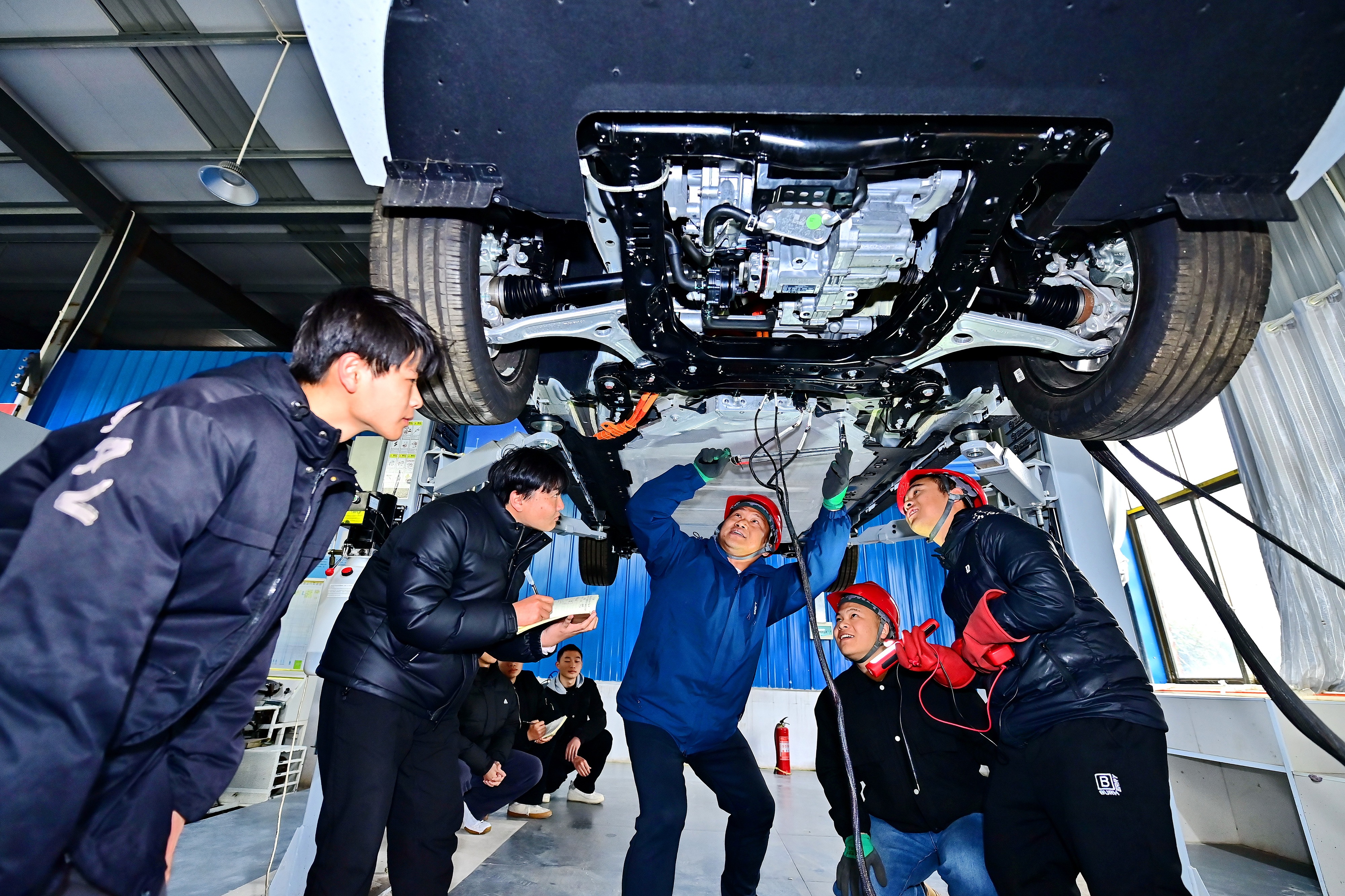 2025年2月，江西省宜春市，豐城市的一所技工學(xué)校實(shí)訓(xùn)基地內(nèi)，新能源汽車運(yùn)維專業(yè)學(xué)生在老師的指導(dǎo)下學(xué)習(xí)新能源汽車電池包檢修技術(shù)。