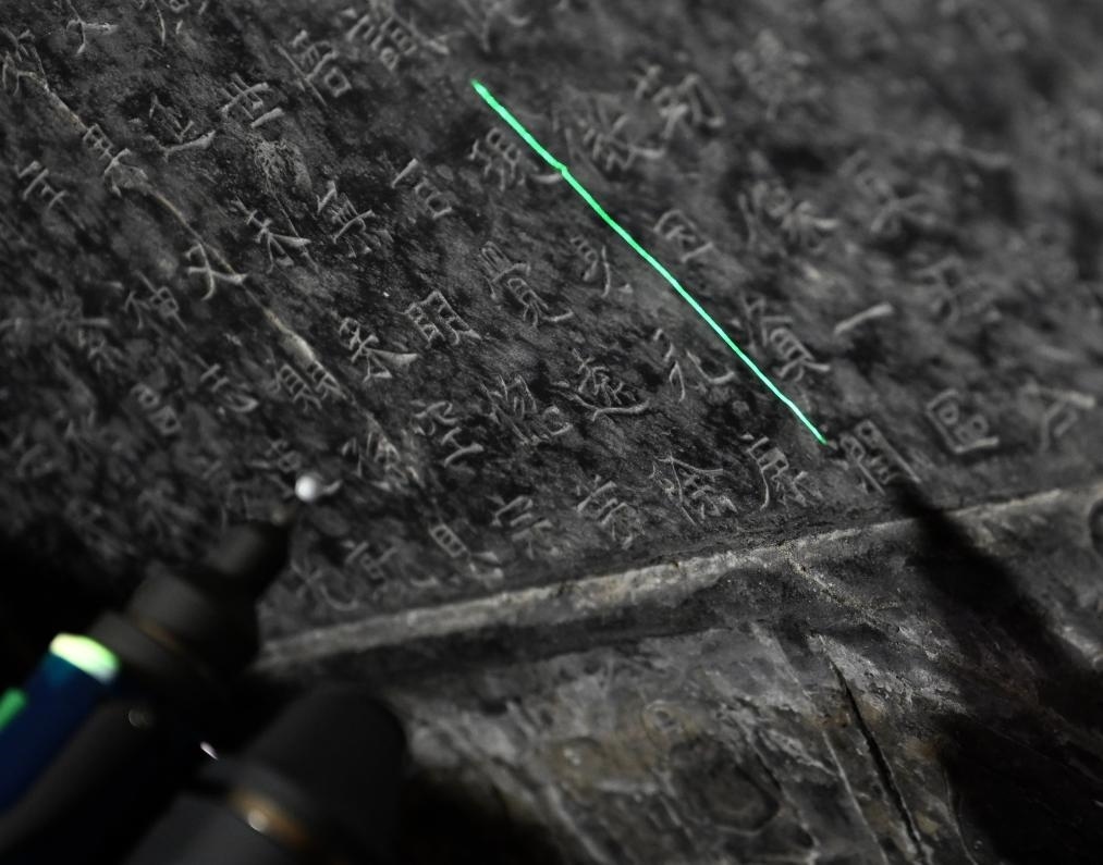 2025年4月9日，龍門(mén)石窟研究院工作人員在古陽(yáng)洞使用關(guān)節(jié)臂掃描儀對(duì)《龍門(mén)二十品》之一進(jìn)行數(shù)字化掃描。新華社記者 李嘉南 攝