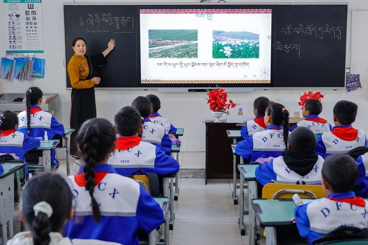 2024年9月27日，在四川省甘孜藏族自治州道孚縣城關(guān)第一完全小學(xué)，采取“藏加模式”教學(xué)的五年級(jí)一班的藏語文課上，準(zhǔn)木周老師指導(dǎo)藏族學(xué)生以家鄉(xiāng)草原風(fēng)物為主題寫作藏語文作文。新華社記者 沈伯韓 攝