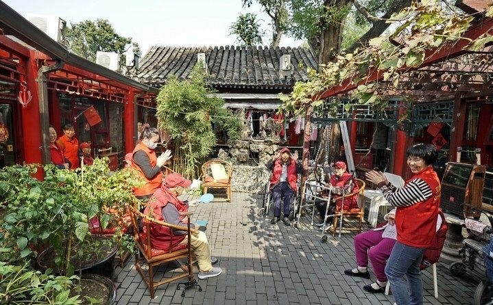 2024年10月12日，鐘樓灣胡同的老年人在社區(qū)內(nèi)的四合院養(yǎng)老驛站休閑。2017年起，北京市先后開展了兩輪背街小巷環(huán)境整治提升行動，完整保留了中軸線生活建筑群的歷史信息，并根據(jù)居民的生活和居住方式進(jìn)行適配化的更新和改造，極大地改善了生活環(huán)境。2023年鐘樓灣胡同被評為“北京最美街巷”。