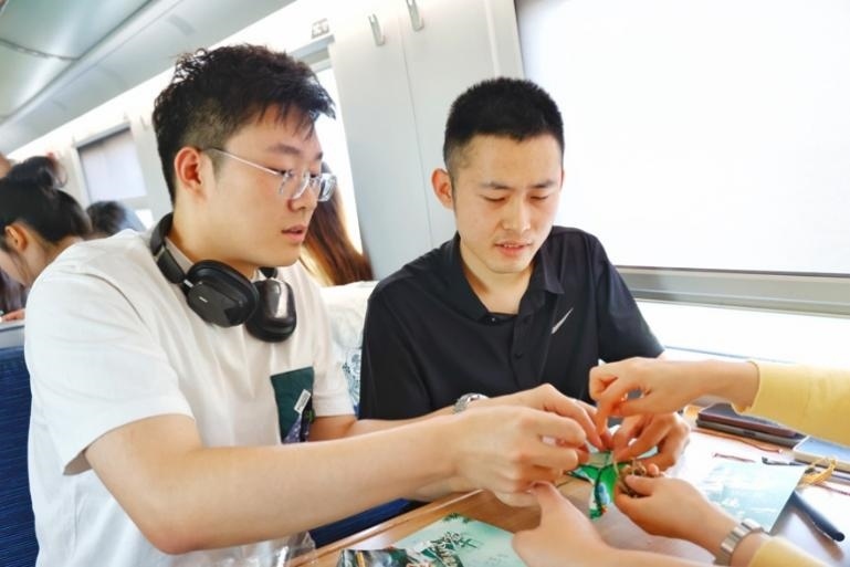 G232次旅客親手制作端午荷包和五彩繩。王磊攝
