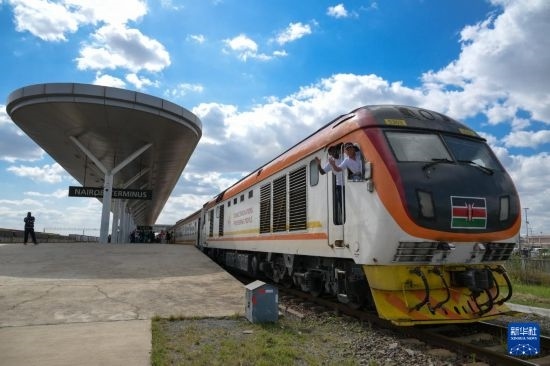 5月31日，在蒙內(nèi)鐵路內(nèi)羅畢站，機(jī)車駕駛員蔣立平（右）和博爾在即將開往蒙巴薩的E2次列車上揮手致意。新華社記者 楊光 攝