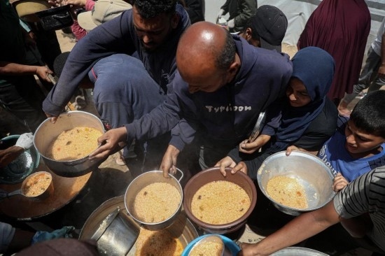 5月28日，人們在加沙城西部的沙提難民營領取救助食物。新華社發(fā)（里澤克·阿卜杜勒賈瓦德攝）