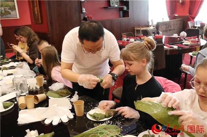 烏克蘭兒童學習體驗包粽子。人民網(wǎng)記者蔡子暢攝